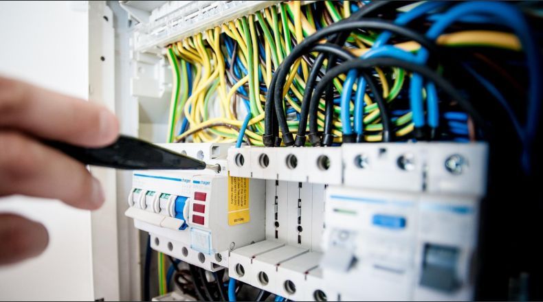 alumno trabajando en uno de los ciclos de electricidad y electronica con un medidor de potencia